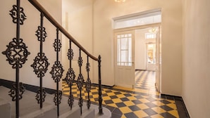A staircase with ornate metal railings and a checkered floor pattern. - TurnKey | Republic Square Apartment I (Praha 1)