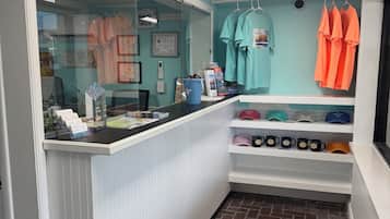 A reception area with a counter, a glass window, and a wall displaying various items.