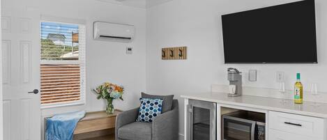 A modern kitchen with a built-in microwave, a coffee maker, and a wine bottle on the counter.