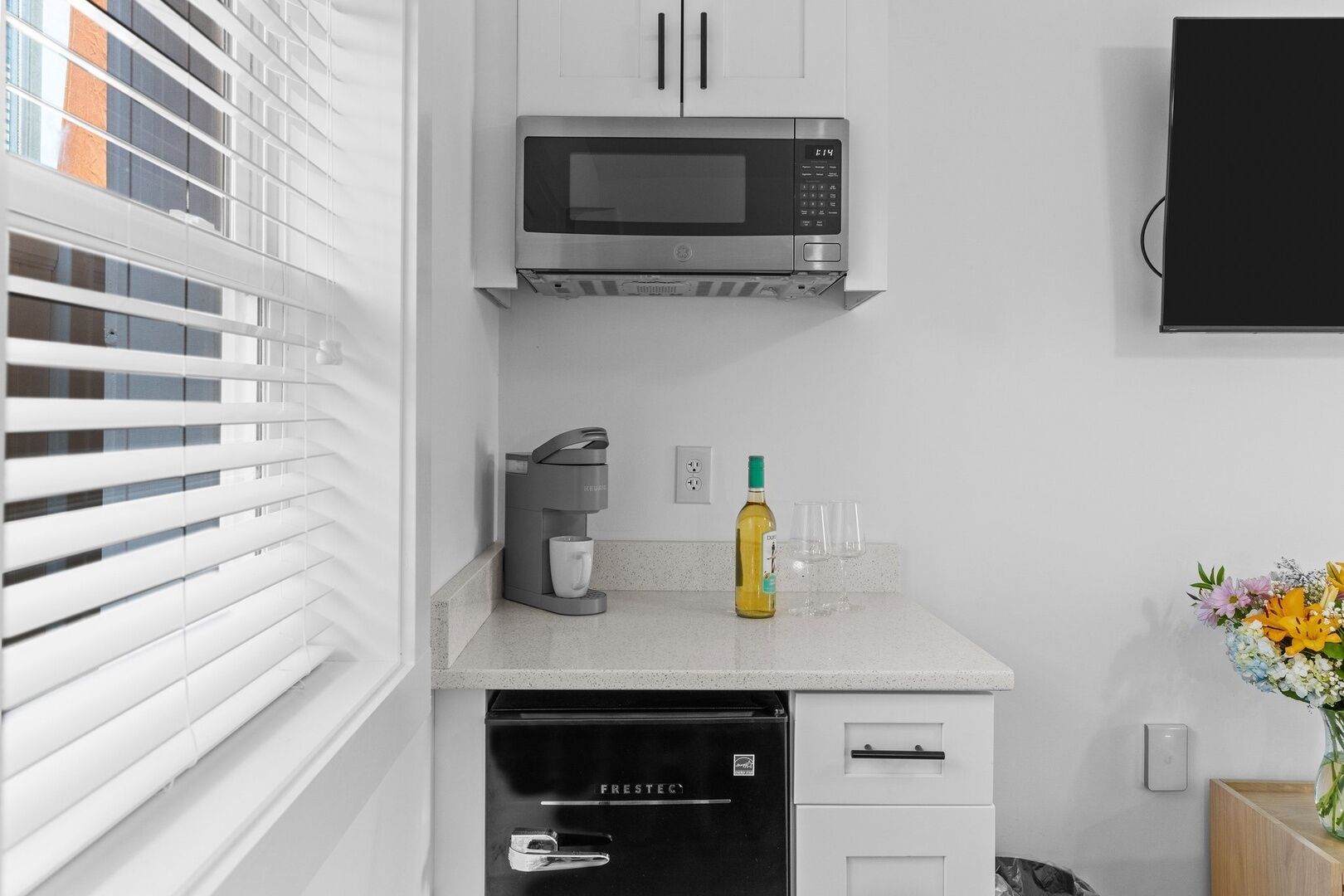 Una cocina moderna equipada con microondas, cafetera y lavavajillas.