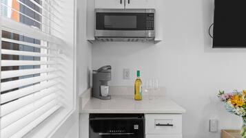 Eine moderne Küche mit Einbau-Mikrowelle, Kaffeemaschine und Geschirrspüler.