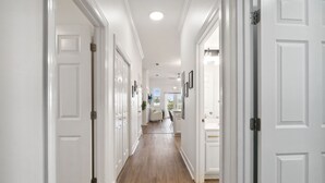 A hallway with white doors and a wooden floor.