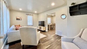 A modern living room with a sofa, armchair, and a TV. - Cozy home. Newly remodeled and easy access to all that Grand Rapids has to offer (Grand Rapids)