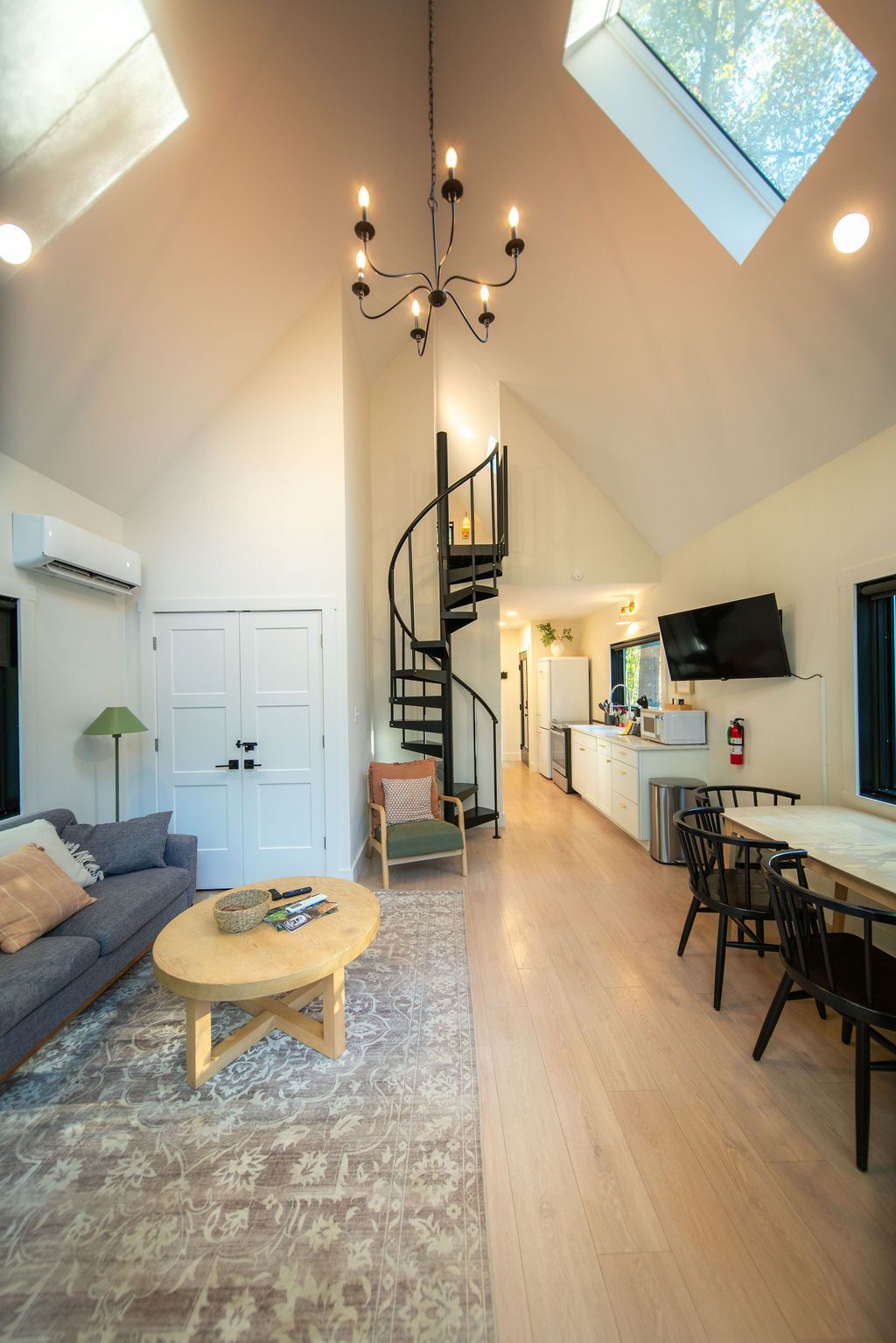 A spacious living area with a staircase, a dining table, and a kitchen area.