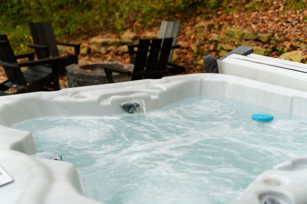 Een bubbelbad met stromend water, omringd door zitplaatsen buiten.