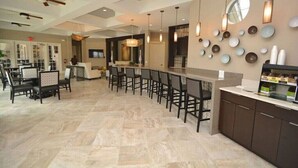 A spacious kitchen with a long bar area, modern lighting fixtures, and a variety of decorative items on the walls. - Solterra Resort-7 Bedrooms 5.5 Bath Pool/Spa-Clubhouse/Lazy River-Near Disney (Davenport)