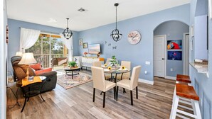 A dining area with a round table, chairs, and a chandelier. - Disney | Condo | Windsor Hills | Water Park (Kissimmee)