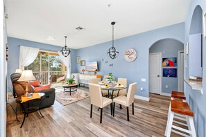 A dining area with a round table, chairs, and a chandelier.