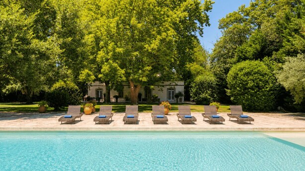 A pool with lounge chairs and a building in the background. - Mas des Bécasses in Provence 22 pax (Arles)