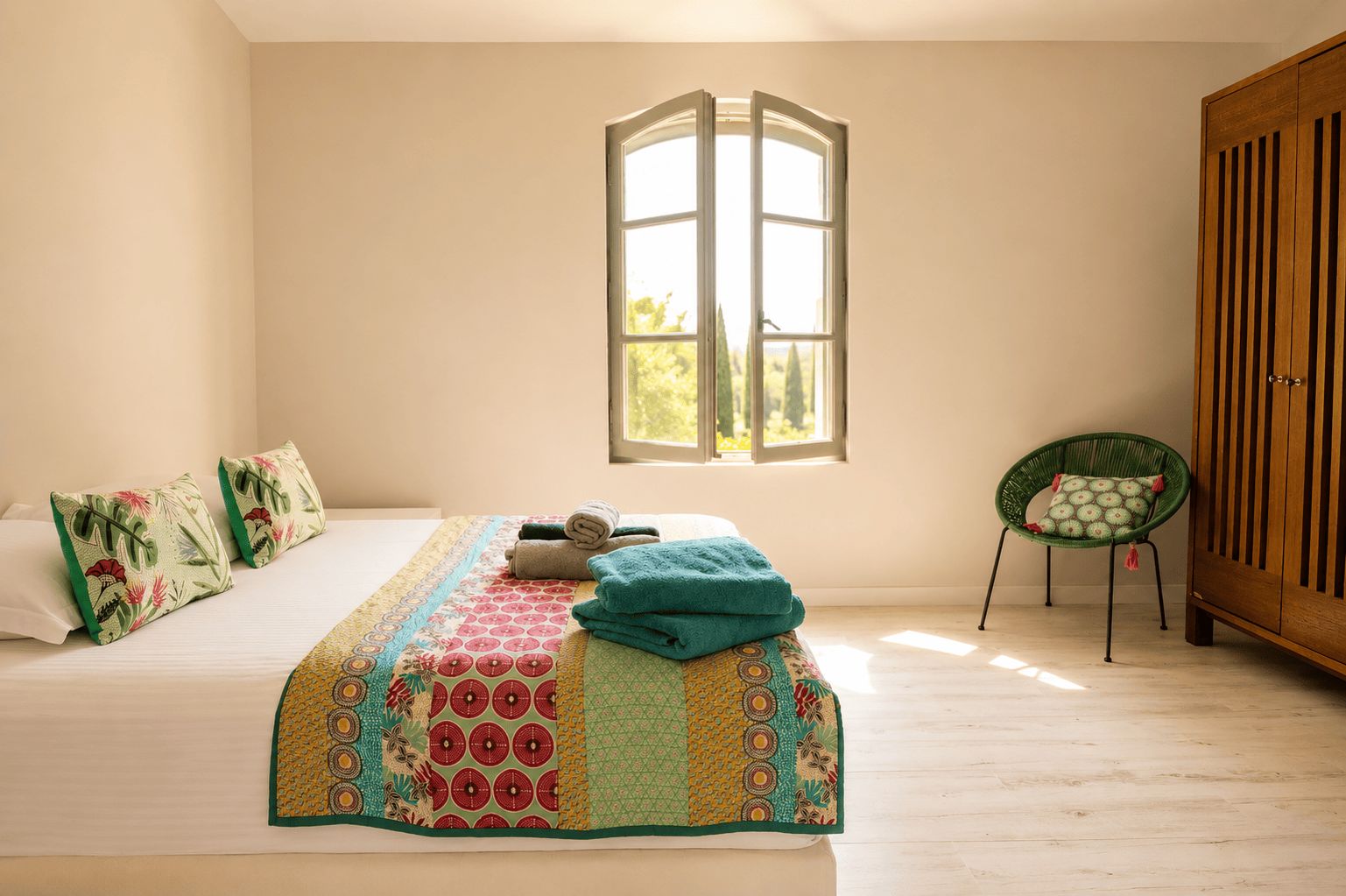 Um quarto com uma cama, janela, cadeira e guarda-roupa.