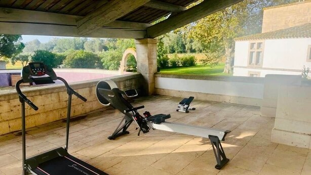 An outdoor gym with a treadmill, rowing machine, and bench press. - Mas des Bécasses in Provence 22 pax (Arles)