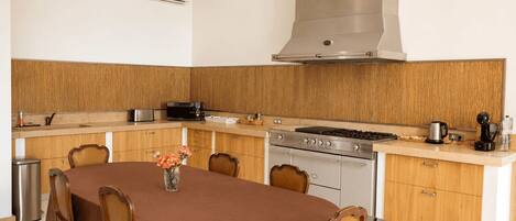 A modern kitchen with a central island, stainless steel appliances, and wooden cabinetry.