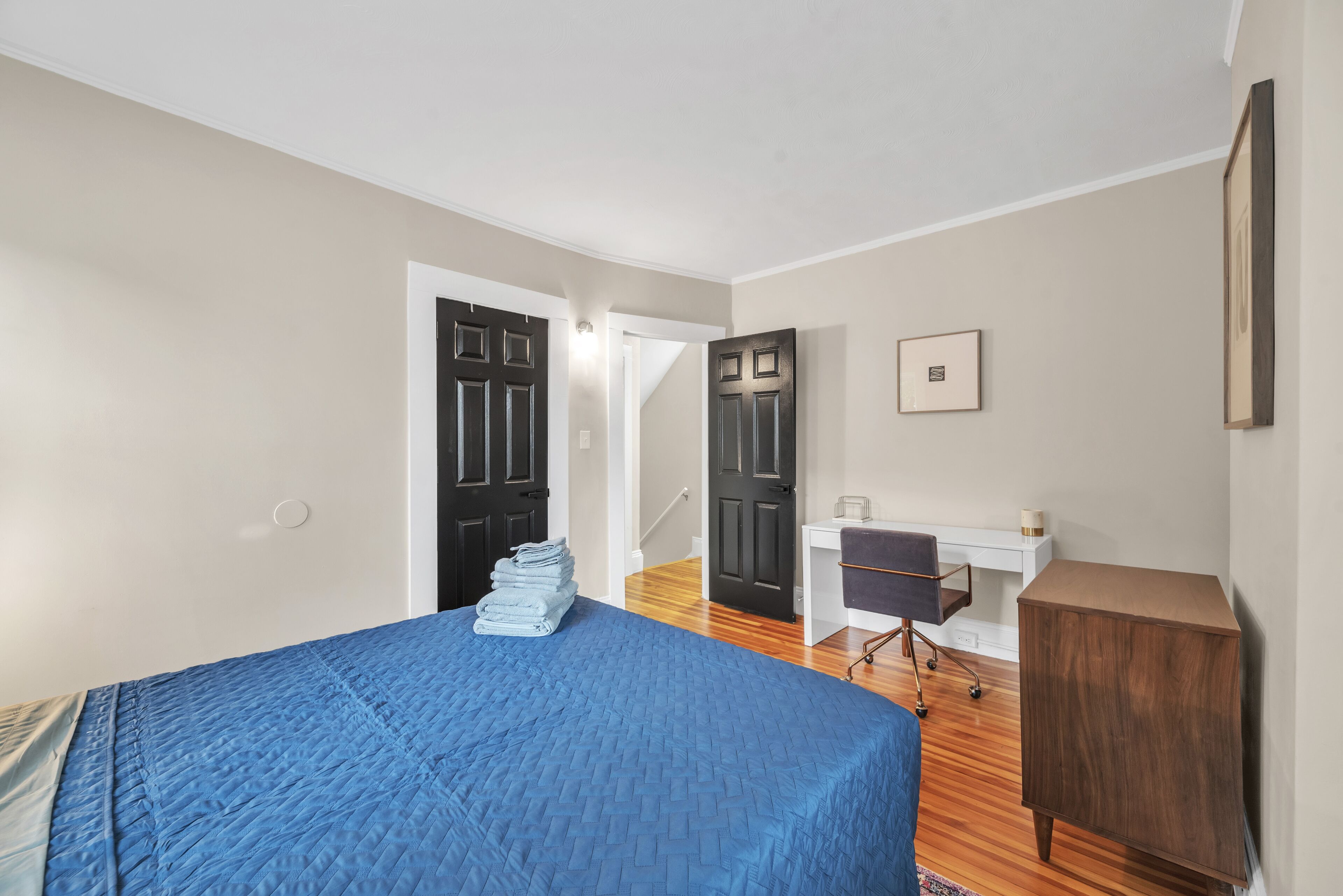 Une chambre à coucher avec un lit, un bureau et une armoire.