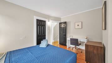 Une chambre à coucher avec un lit, un bureau et une armoire.