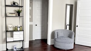 A bedroom with a bed, a bookshelf, a chair, a door, and a mirror. - Walk to Mercer, Private Suite w/ Workspace, Fast WiFi + Parking (Macon)