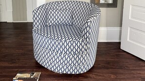 A round, patterned armchair in a hallway with a wooden floor, a mirror, and a door with a decorative frame. - Walk to Mercer, Private Suite w/ Workspace, Fast WiFi + Parking (Macon)