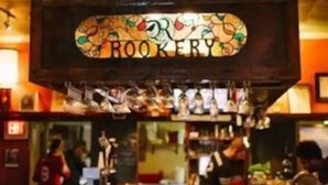 A bar area with a sign reading "ROOKERY" and a display of various bottles and glasses. - Walk to Mercer, Private Suite w/ Workspace, Fast WiFi + Parking (Macon)