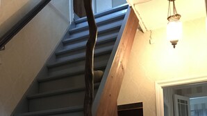 A staircase with wooden handrails and a light fixture above. - Traditional Jūrmala house. (Jūrmala)