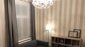 A modern living room with a sofa, a coffee table, a floor lamp, and a bookshelf. - Traditional Jūrmala house. (Jūrmala)