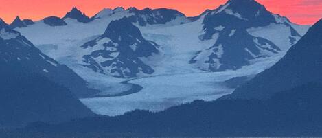 A mountain landscape with snow-covered peaks and a glacier.