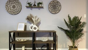 A wooden console table with two white vases, a framed certificate, and a decorative basket. - Siesta Beach Getaway - Minutes to Beach, Shops, Dining (Sarasota)