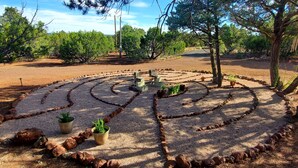 A landscaped garden with a gravel path, potted plants, and trees. - Dog friendly peaceful retreat for 2 (Concho)