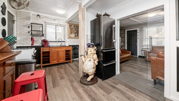 A modern kitchen with a wooden cabinet, a red stool, and a unique statue. - Bill Murray - Private Barcade and Outdoor Lounge - OSU/Clintonville/CrewStadium (Columbus)