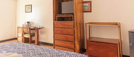 Une chambre à coucher avec un lit, une armoire en bois, un bureau et une chaise.