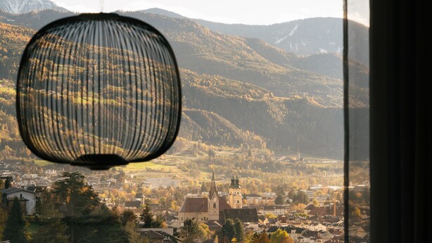 A view of a town with mountains in the background, a church, and a hanging lamp. - Apartment 'Cityview Apt 1' with Mountain View, Private Terrace and Wi-Fi (Bressanone)