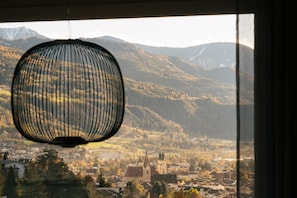 Une vue d’une ville avec des montagnes en arrière-plan, une église et une lampe suspendue.