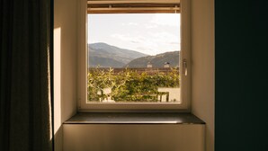 Una ventana con vistas a un paisaje montañoso y un edificio a lo lejos.