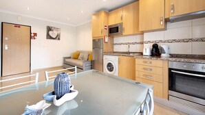 A modern kitchen with wooden cabinets, a stainless steel refrigerator, a microwave, a washing machine, and an oven. - Apartment "Clube Praia da Rocha 3" with Balcony & Wi-Fi (Portimao)