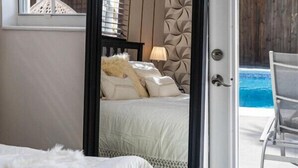 Une chambre avec un lit, une porte donnant sur un espace piscine et une fenêtre offrant une vue sur la verdure.