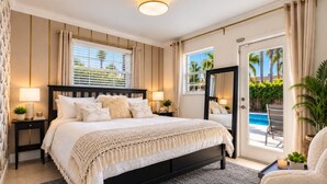 Un dormitorio con una cama grande, dos mesitas de noche, un espejo y vista a una piscina.