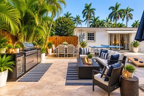 Une terrasse extérieure équipée d’un barbecue, d’un espace repas et de sièges.
