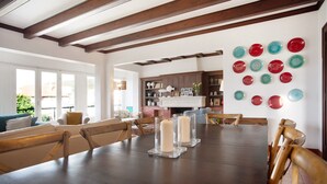 A dining area with a wooden table, chairs, and a wall with decorative plates. - Vacation Home "São Martinho All The Best" with Sea View, Shared Pool & Wi-Fi (São Martinho do Porto)