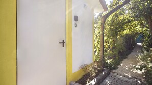 Una puerta amarilla con el número 3 y un buzón pequeño en la pared.