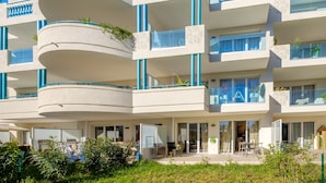 A multi-story hotel with balconies, large windows, and a garden area. - Apartment 'Le Jasmin' with Private Terrace, Wi-Fi and Air Conditioning (Nice)