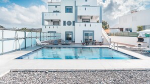 Ein modernes, mehrgeschossiges Gebäude mit Schwimmbad, Außenbereich und freiem Blick auf die umliegende Landschaft.