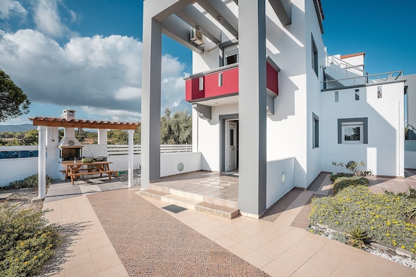 Une maison moderne dotée d’un patio, d’un espace barbecue et offrant une vue sur la mer.