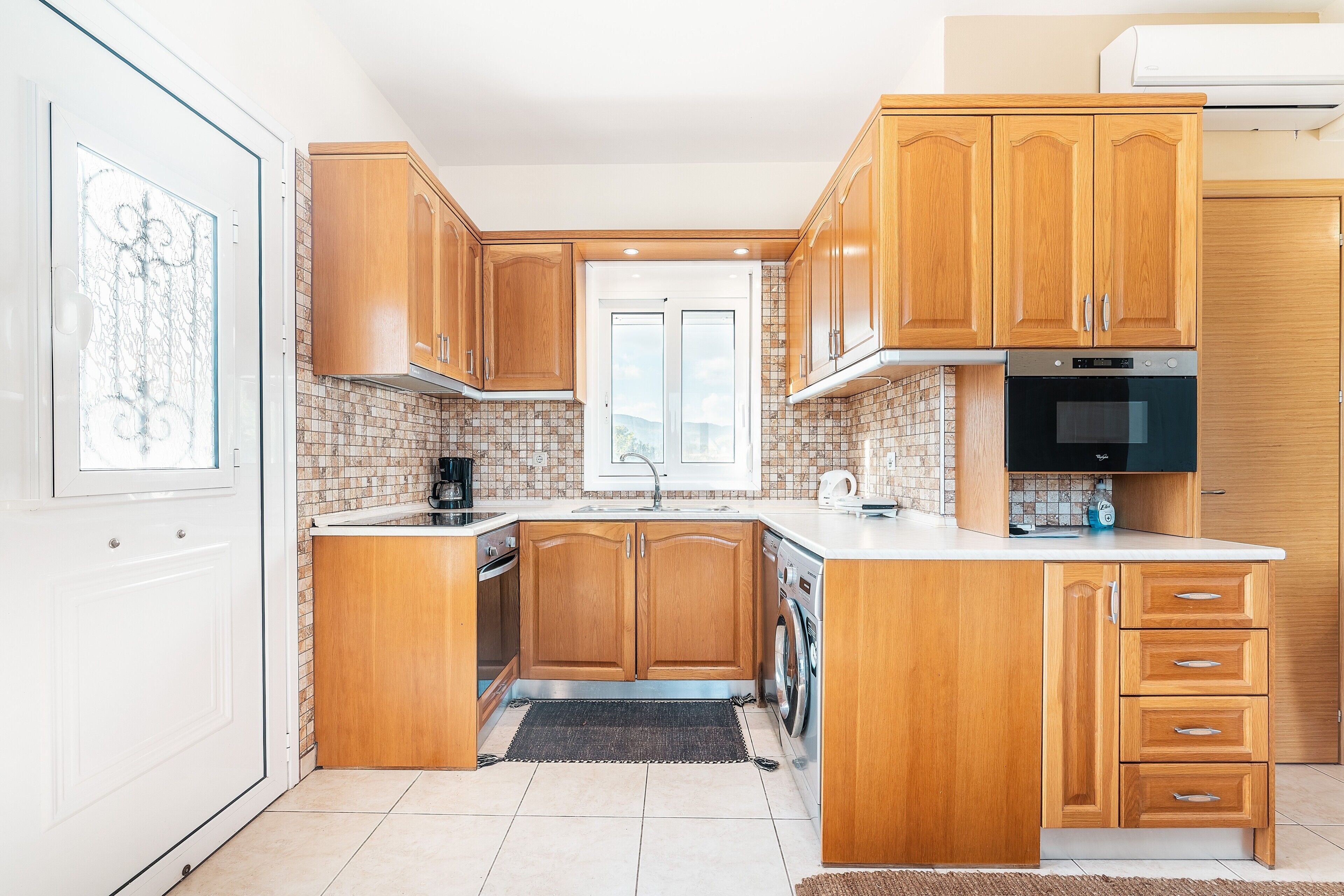 A kitchen with wooden cabinets, a built-in oven, and a microwave.