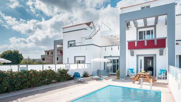 Ein modernes Gebäude mit Pool, Außenbereich und blauem Himmel.