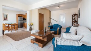 Ein Wohnzimmer mit Sofa, Couchtisch und einem Essbereich mit Stühlen und Tisch.