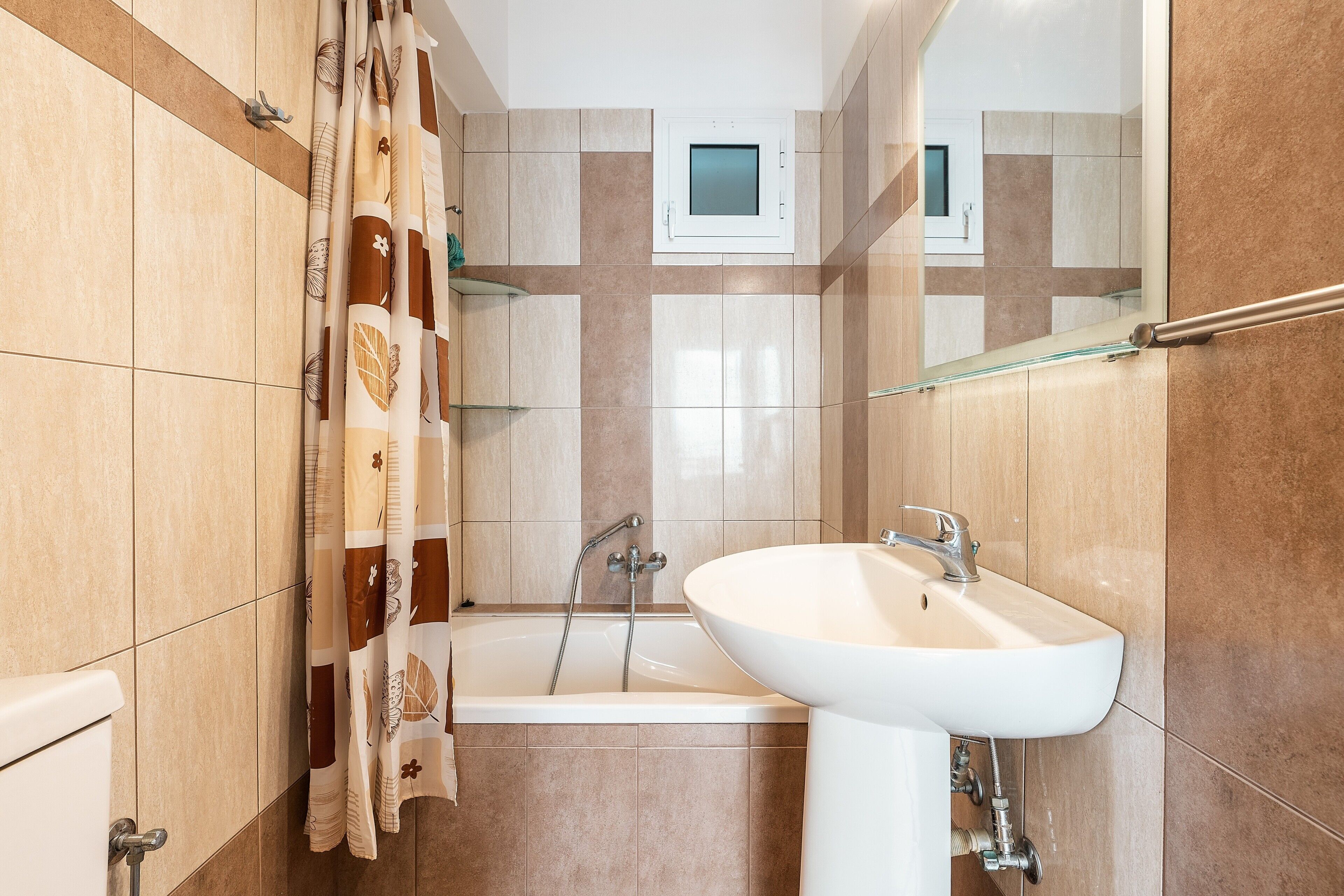 Un baño con bañera, lavamanos y cortina de ducha.