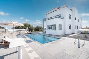 A modern two-story building with a swimming pool, lounge chairs, and a pergola. - Country House 'White Pearl' with Private Pool, Private Terrace and Wi-Fi (Rhodes)