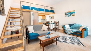 Un salon avec un canapé, une table basse et un tapis à motifs.