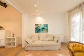 Ein Wohnzimmer mit einem beigen Sofa, einem weißen Schrank, einem gelben Sessel und einem Bild an der Wand.