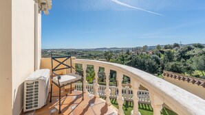 A balcony with a chair, a table, and a radiator. - Villa 'Villa in Mijas Golf' with Sea View, Wi-Fi and Air Conditioning (Mijas)