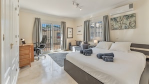 A bedroom with a large bed, a desk, a chair, and a wardrobe. - Villa 'Villa in Mijas Golf' with Sea View, Wi-Fi and Air Conditioning (Mijas)