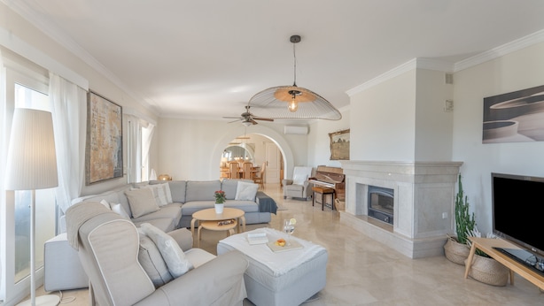 A spacious living room with a sectional sofa, a fireplace, a television, and a ceiling fan. - Villa 'Villa in Mijas Golf' with Sea View, Wi-Fi and Air Conditioning (Mijas)
